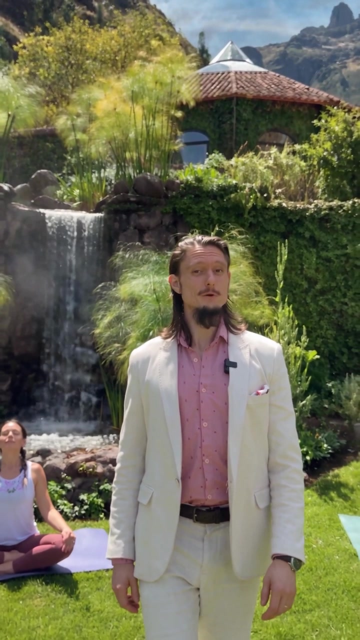 Florian Rolke beside the waterfall garden while a guest practices yoga on the lawn