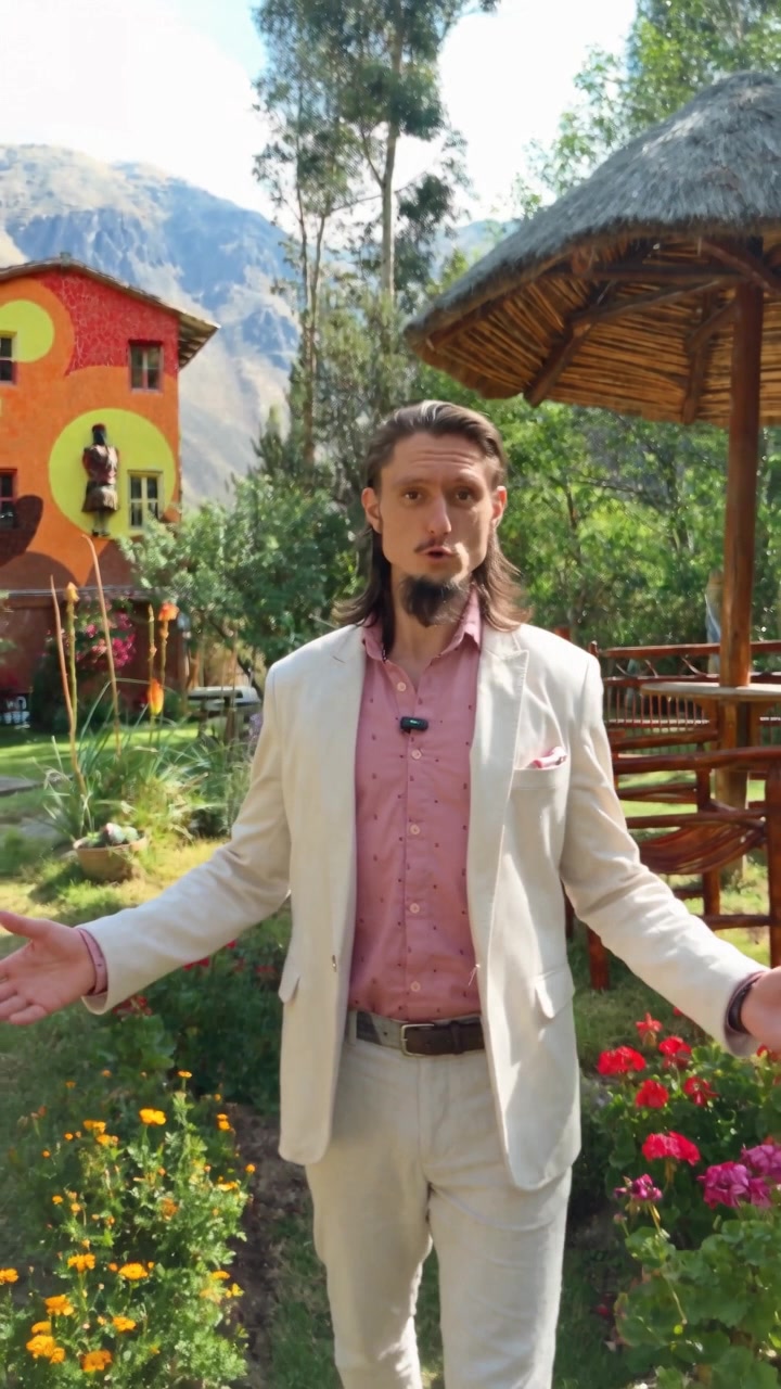 Florian Rolke in the retreat garden, arms open, a thatched umbrella and painted lodge behind him